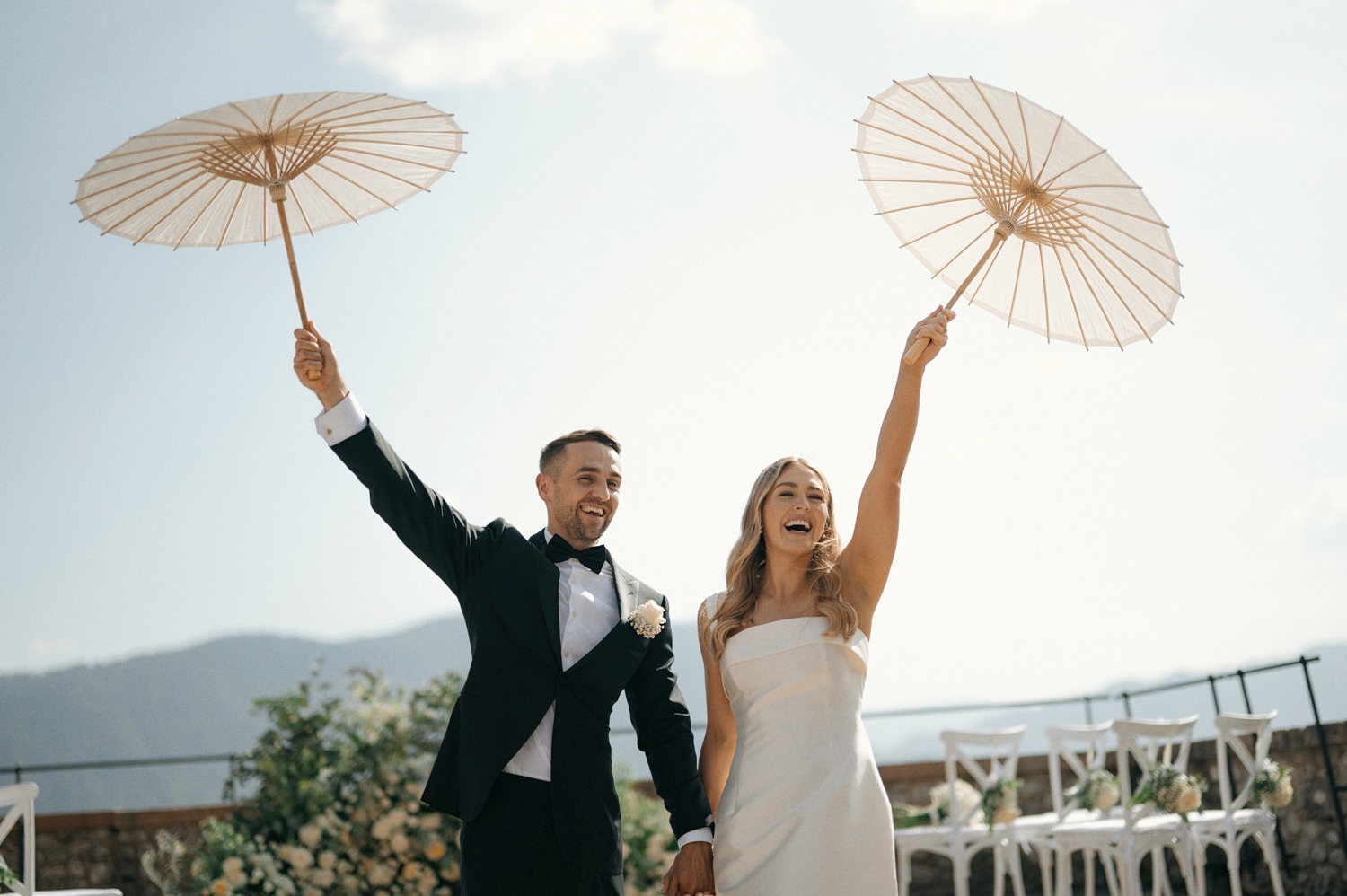 bride and groom with umbrellas at castle bled